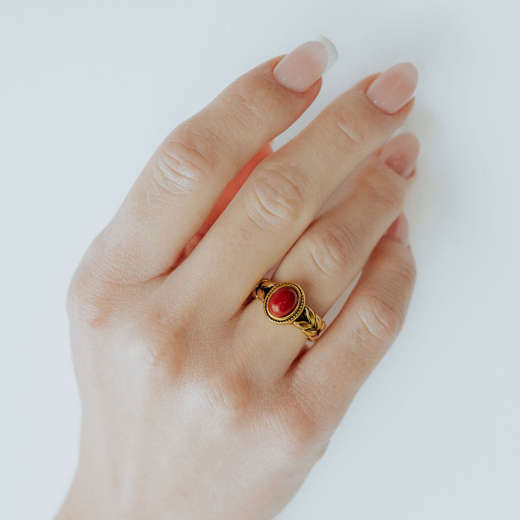 Close-up of Beloved Daughter ring showing the red stone and wheat-patterned edges