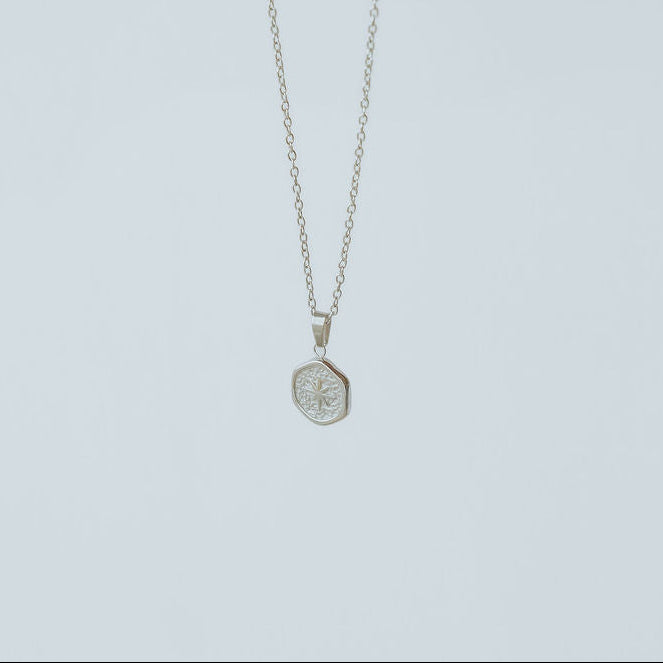 Gold and silver Guiding Star necklace displayed flat, symbolizing the Christmas star that led the wise men