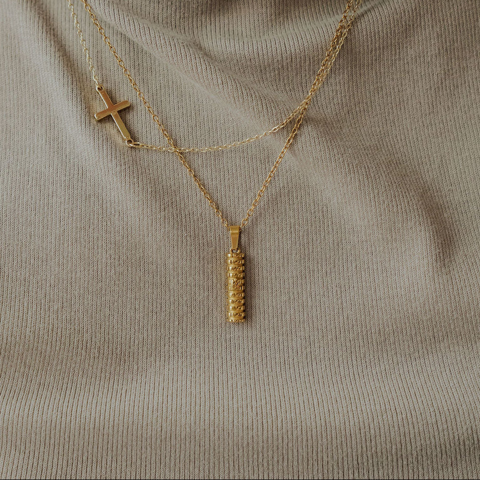 Gold Mezuzah necklace with Shin symbol and Western Wall design displayed flat.